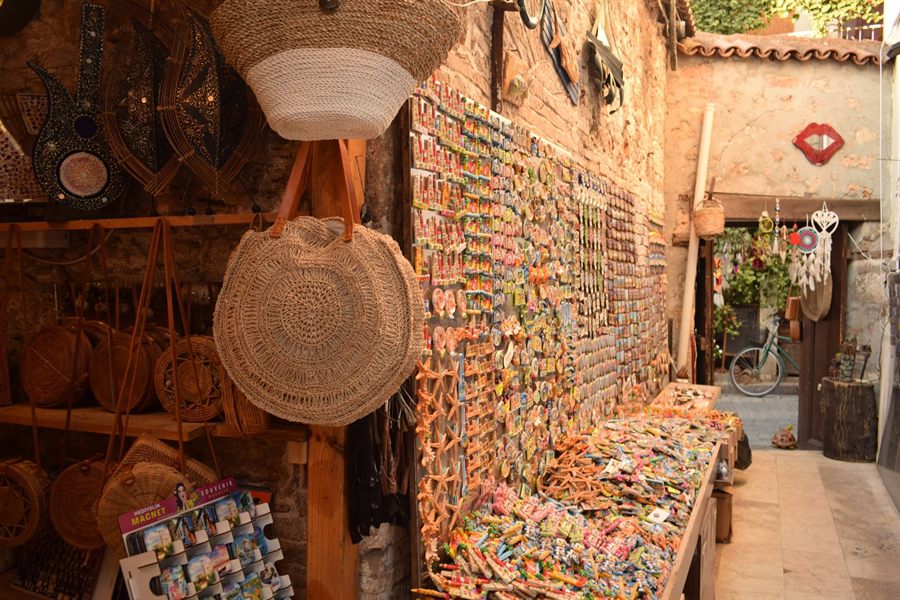 Bazaar alley in Antalya lined with woven bags and walls of souvenir magnets